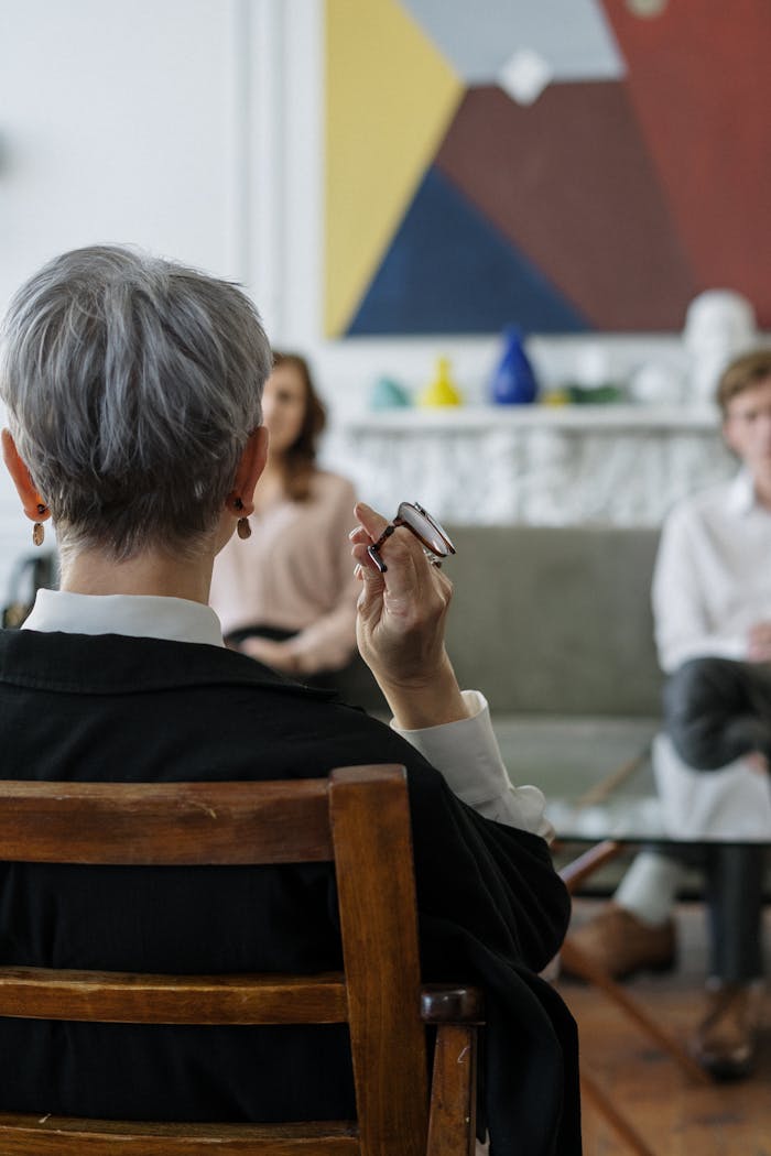 A therapist leads a couples therapy session in a modern office setting.